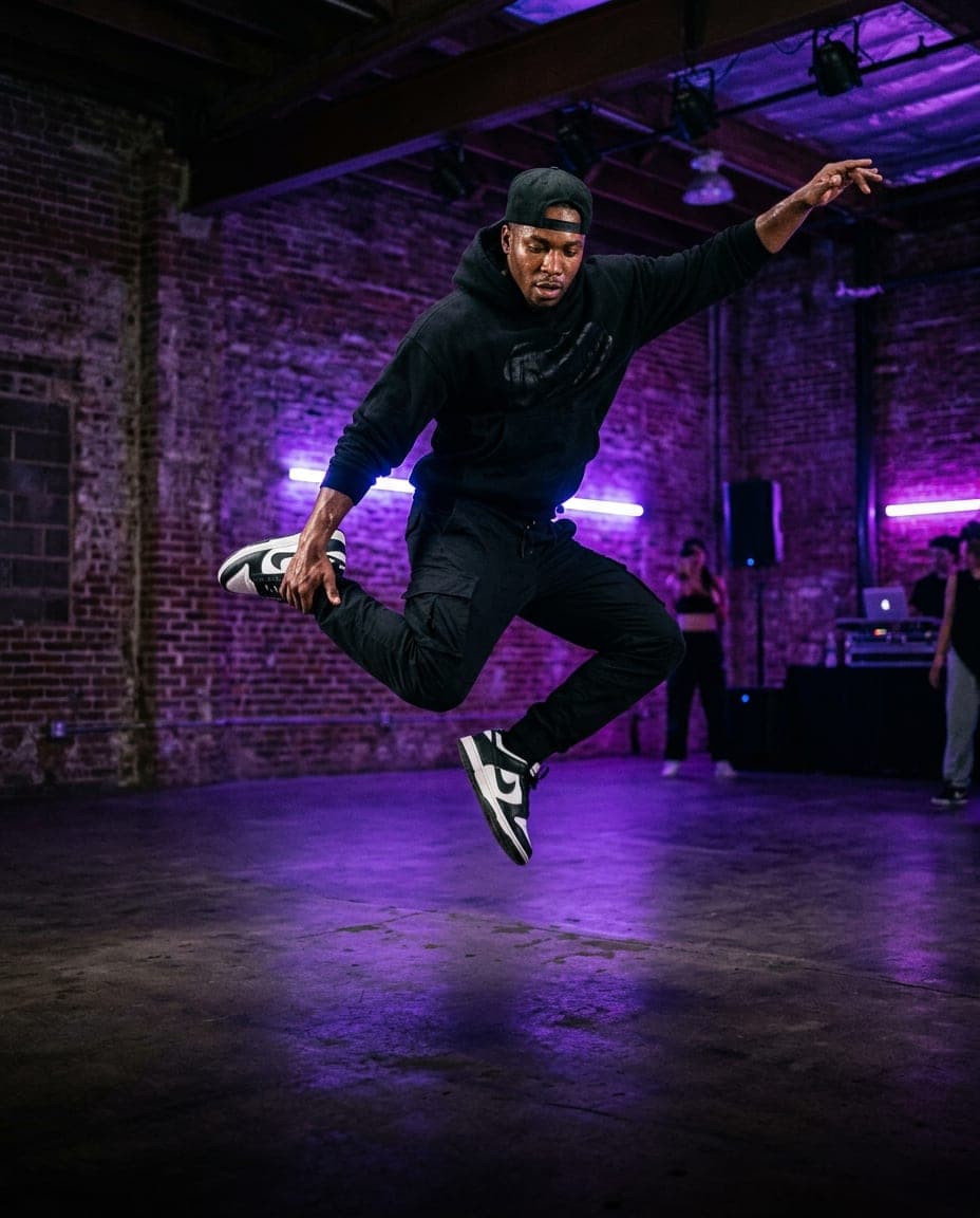 Un bailarín de hip-hop en pleno salto en un estudio urbano con luces moradas