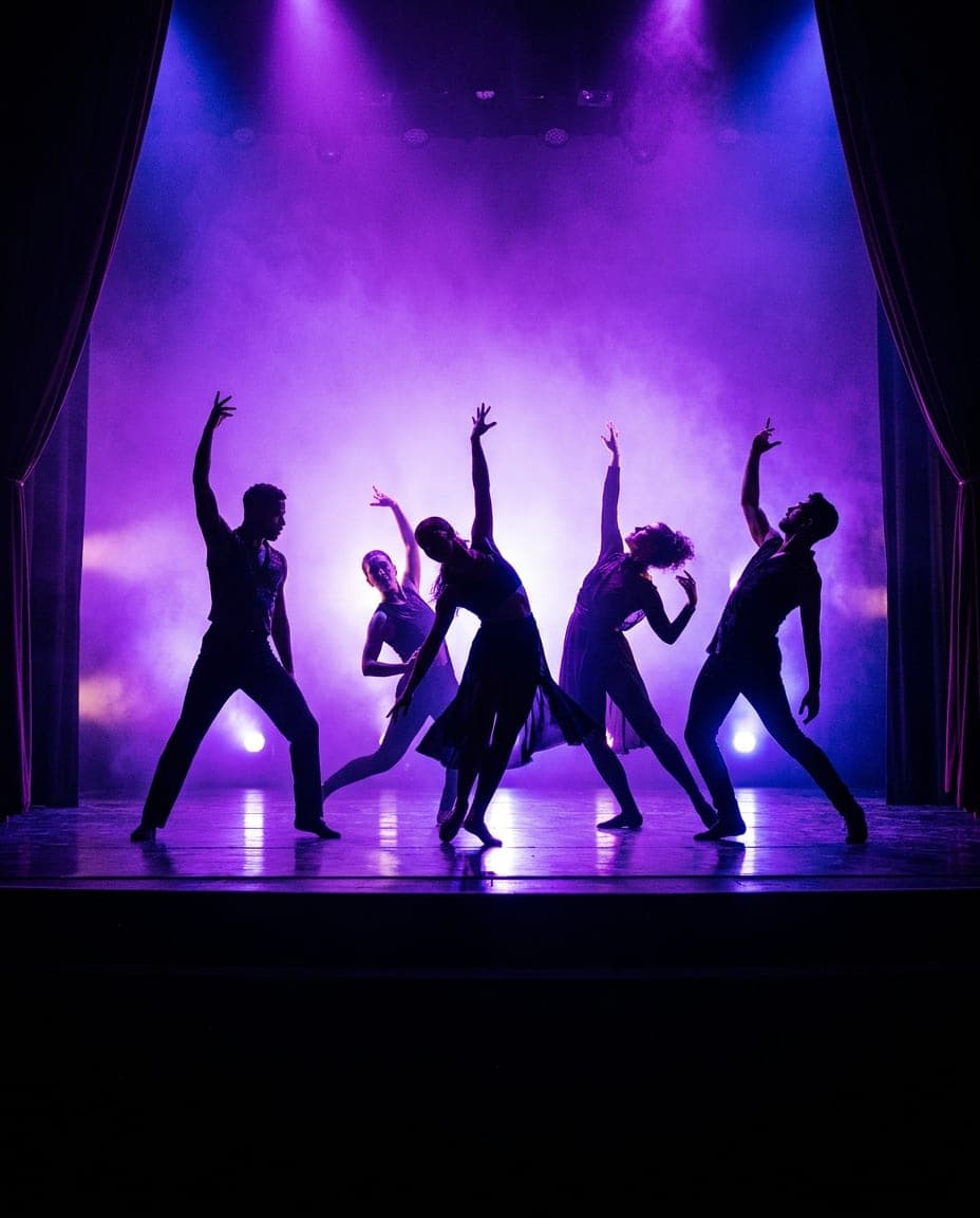 Un elenco de artes escénicas en un escenario de teatro bajo luces violetas